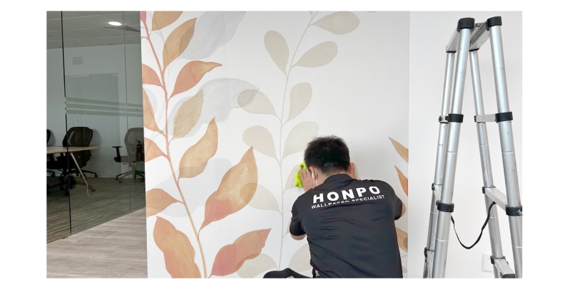 Honpo professional installer installing botanical-themed wallpaper in an office